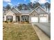 Charming single-story home featuring a well-manicured lawn and attached two-car garage at 7417 Jennadee Dr, Fairburn, GA 30213