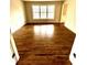 Spacious living room with shining hardwood floors and bright natural light from the large window at 2610 Woodridge Chase, Canton, GA 30114