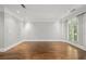 Bright living room featuring hardwood floors, white trim, and large arched window overlooking exterior greenery at 2960 S Pharr Nw Ct # N2, Atlanta, GA 30305