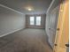 Spacious bedroom with neutral carpet, crown molding, and natural light from windows at 3019 Fairway Dr, Villa Rica, GA 30180