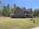 Charming gray brick home showcasing a manicured lawn and inviting front porch at 3019 Fairway Dr, Villa Rica, GA 30180