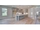 Modern kitchen with gray cabinets, a large island, and stainless steel appliances at 26 Homesite Cooper E Cv, Fayetteville, GA 30214