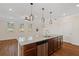 Open-concept kitchen with a granite island with a sink and modern pendant lighting fixtures at 2881 Grandin Way, Marietta, GA 30008