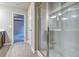 Bright bathroom featuring a glass enclosed shower, wood-look flooring and a hallway entrance at 4341 Portsbrook Ave, Snellville, GA 30039