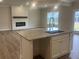 Modern kitchen island with granite countertop and sink, overlooking the living area and fireplace at 4341 Portsbrook Ave, Snellville, GA 30039