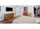 Bedroom with dresser and TV, leading to organized walk-in closet and white door at 6163 Talmadge Nw Run, Acworth, GA 30101