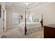 Cozy bedroom with tray ceiling, carpet, two windows, and four-poster bed at 6163 Talmadge Nw Run, Acworth, GA 30101
