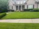 Well-manicured front lawn leading to a stately brick home with a covered entrance and mature landscaping at 6163 Talmadge Nw Run, Acworth, GA 30101