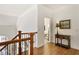 Upstairs hallway with hardwood floors, staircase, and side table with lamp at 6163 Talmadge Nw Run, Acworth, GA 30101