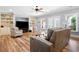 Cozy living room featuring hardwood floors, ceiling fan, and large-screen TV at 6163 Talmadge Nw Run, Acworth, GA 30101