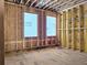 Unfinished bedroom with open stud walls, under-floor insulation, and two windows for natural light at 00 Kingsboro Rd # 1, Atlanta, GA 30326