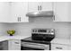 Close-up of a modern stove, white cabinets, and stylish fixtures in this kitchen at 1070 Kirkland Rd, Covington, GA 30016