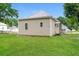 Back exterior view of tan house with a metal roof and grassy yard at 1847 New Ne St, Conyers, GA 30012