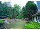 Backyard featuring a lush lawn, mature trees, landscaping, and a stone pathway at 3390 Vista Creek Dr, Dacula, GA 30019