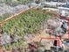 An expansive aerial view of the wooded lot, bordered in red, with surrounding buildings at 1891 Highway 81 E, Mcdonough, GA 30252