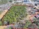 Expansive aerial view of the wooded lot, bordered in red, with surrounding buildings and roads at 1891 Highway 81 E, Mcdonough, GA 30252