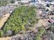 Expansive aerial view of a wooded lot with surrounding buildings and roads at 1891 Highway 81 E, Mcdonough, GA 30252