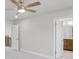 Spacious bedroom featuring a ceiling fan, carpet flooring, and doorway views of the stairs and bathroom at 5707 Tillman Way, Powder Springs, GA 30127