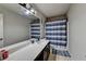 Bathroom featuring a long vanity, large mirror, and blue and white striped shower curtain at 831 Pine Arbor Ln, Lawrenceville, GA 30043