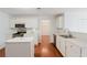 The bright white kitchen is equipped with stainless appliances, an island, and views into the dining room at 59 Pompas Ct, Dallas, GA 30157