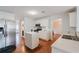 Bright kitchen features stainless steel appliances, island, white cabinetry, and hardwood floors at 59 Pompas Ct, Dallas, GA 30157