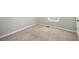 A minimalist bedroom features neutral carpet, pale green walls, and a window at 1165 Hardin Bridge Rd, Euharlee, GA 30145