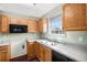 Functional kitchen with wooden cabinets, black appliances and lots of natural light at 1165 Hardin Bridge Rd, Euharlee, GA 30145