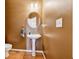 Powder room with pedestal sink, toilet, and oval mirror at 1464 Oglethorpe Dr, Suwanee, GA 30024