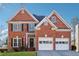 Two-story brick home with a two-car garage and manicured lawn at 1464 Oglethorpe Dr, Suwanee, GA 30024