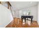 Living room with hardwood floors, a grand piano, and plenty of natural light at 1464 Oglethorpe Dr, Suwanee, GA 30024
