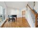 Living room featuring hardwood floors, large windows, and a grand piano at 1464 Oglethorpe Dr, Suwanee, GA 30024