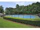 Outdoor tennis court in a fenced-in area with lush green surroundings for active recreation at 1464 Oglethorpe Dr, Suwanee, GA 30024