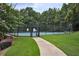 Outdoor tennis court in a fenced-in area with a sidewalk leading to the entrance gate at 1464 Oglethorpe Dr, Suwanee, GA 30024