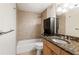 Cozy bathroom featuring tiled walls, a shower-tub combo, and a granite countertop vanity at 2479 Peachtree Ne Rd # 605, Atlanta, GA 30305