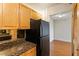Cozy kitchen featuring granite countertops, a refrigerator, wood cabinets, and a doorway to the dining area at 2479 Peachtree Ne Rd # 605, Atlanta, GA 30305