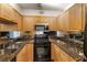 Galley kitchen featuring granite countertops, stainless microwave and oven, and mirrored backsplash at 2479 Peachtree Ne Rd # 605, Atlanta, GA 30305