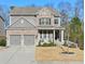 Two-story brick home with gray siding, two-car garage, and landscaped yard at 1868 Lakeview Bend Way, Buford, GA 30519