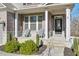 Brick front porch with white columns, stone flooring, and two chairs at 1868 Lakeview Bend Way, Buford, GA 30519