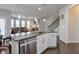 Modern kitchen with island, stainless steel appliances, and view of living room at 1868 Lakeview Bend Way, Buford, GA 30519