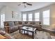 Spacious living room with large sectional sofa and multiple windows at 1868 Lakeview Bend Way, Buford, GA 30519