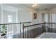 Open upper hallway with a metal railing and hardwood floors at 1868 Lakeview Bend Way, Buford, GA 30519