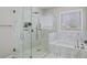 Bathroom with a glass-enclosed shower, soaking tub, and marble tile at 2195 Morgan Ne Rd, Marietta, GA 30066