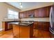 Kitchen features dark wood cabinets, granite countertops, and stainless steel appliances at 2969 Rivergreen Se Ln, Atlanta, GA 30339
