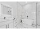 Elegant bathroom with a freestanding tub, marble-style walls, a glass shower, and sleek fixtures at 2753 Camp Branch Rd, Buford, GA 30519