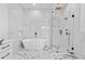 Modern bathroom featuring marble-style walls, a glass shower, a sleek soaking tub, and gold fixtures at 2753 Camp Branch Rd, Buford, GA 30519