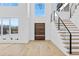 Bright foyer with hardwood floors, modern staircase, and a contemporary front door, creating an inviting entrance at 2753 Camp Branch Rd, Buford, GA 30519