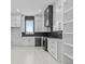 Modern white kitchen with stainless steel appliances, island and black backsplash at 2753 Camp Branch Rd, Buford, GA 30519