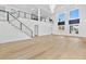 A luxurious living space with a staircase to a second floor, large windows, and bright hardwood floors at 2753 Camp Branch Rd, Buford, GA 30519