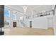 Bright, open-concept living space with hardwood floors, a modern staircase, and elegant lighting fixtures at 2753 Camp Branch Rd, Buford, GA 30519
