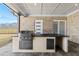 Outdoor kitchen featuring built-in barbecue, sink, and counter space; backyard in background at 2753 Camp Branch Rd, Buford, GA 30519